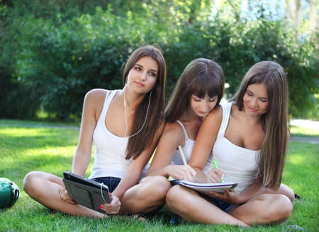 Happy young girls having fun using a tablet computerの写真素材