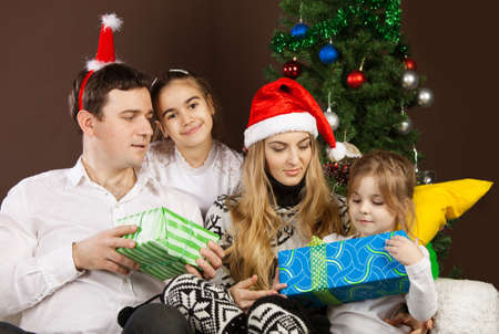 Happy family opening Christmas presents near the Christmas treeの写真素材