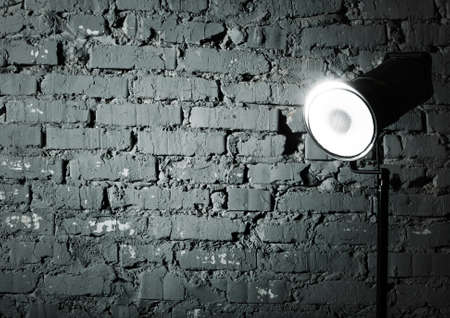 Studio flash near the gray damaged brick wallの写真素材