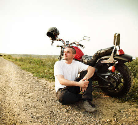 Biker on the country road against the skyの写真素材