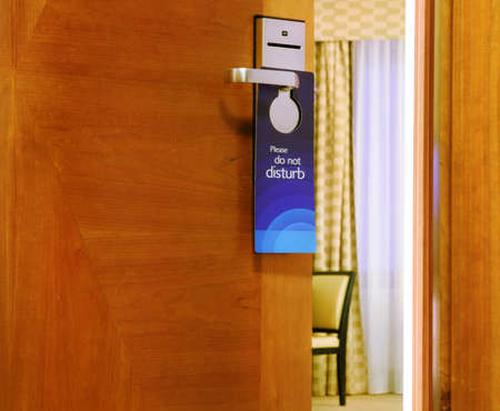 Please do not disturb sign hanging on open door in a hotelの写真素材