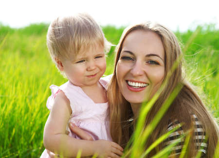 Happy mother and her little daughter in the summer fieldの写真素材