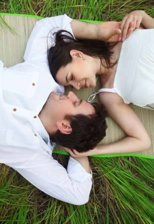 Happy young smiling couple on the summer medow outdoorsの写真素材