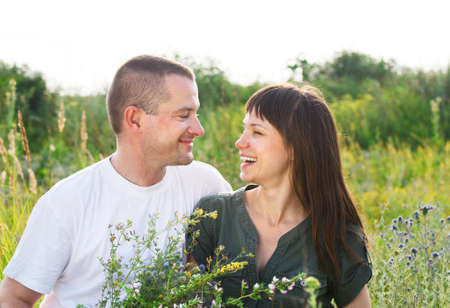 Happy young smiling couple with flowers outdoorsの写真素材