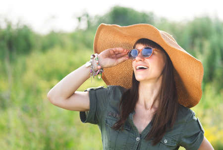 Smiling brunette woman in hat in summer dayの写真素材