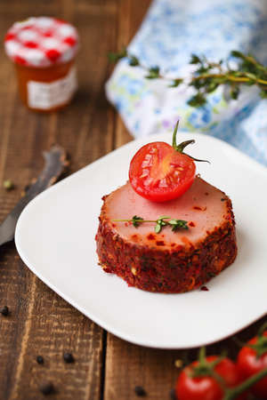 Tasty duck pate appetizer with fresh herbs, tomatoes and jamの写真素材