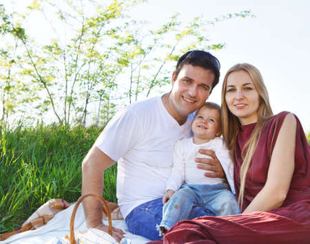 Happy young family on spring picnic outdoorsの写真素材