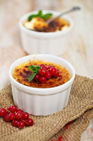 Creme brulee (cream brulee, burnt cream) with red currant and mintの写真素材