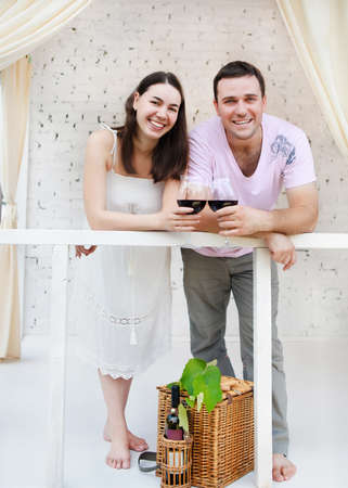 Young happy couple enjoying a glasses of red wine on terraceの写真素材