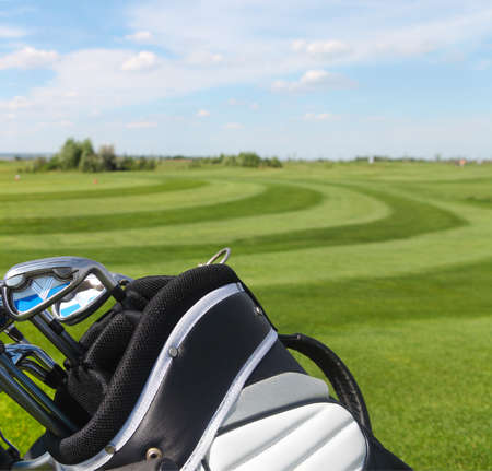 Golf clubs in golfbag, green grass backgroundの写真素材