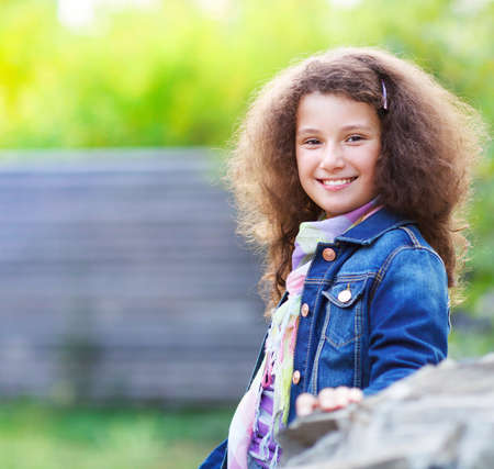 Portrait of the smiling happy little girl outdoorの写真素材