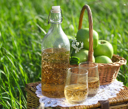 Apple drink and basket with green apples outdoorsの写真素材