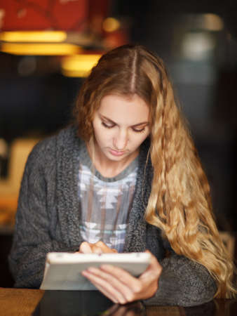 Young woman with touch screen tablet computer in cafeの写真素材