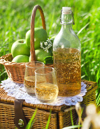 Apple drink and basket with green apples outdoorsの写真素材