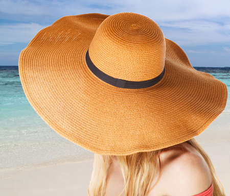Portrait of young beautiful woman in hat on the summer beachの写真素材
