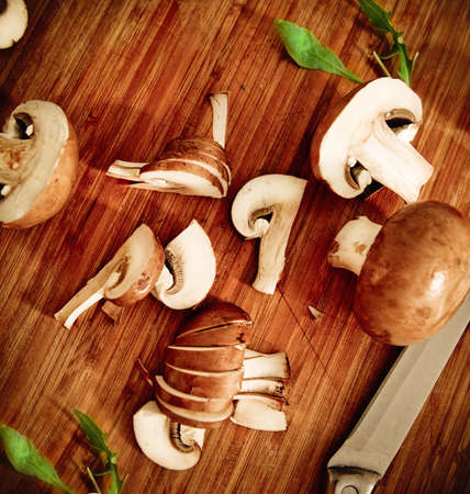 Meal preparation process. Knife, salad, mushrooms on the wooden backgroundの写真素材