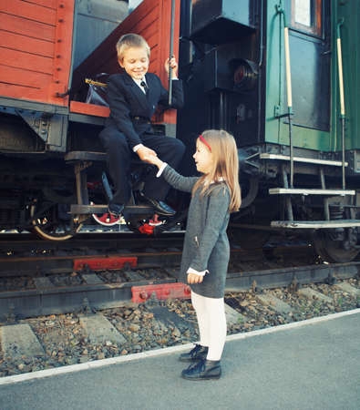 little boy and little girl near the retro trainの写真素材