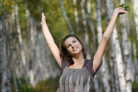 Closeup portrait of a pretty smiling teen girl in autumn parkの写真素材