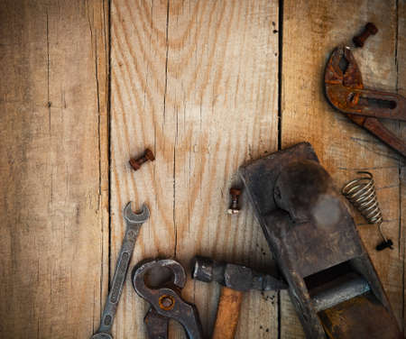 Dirty set of hand tools on a wooden background