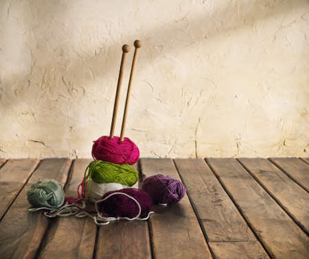 Colorful balls of yarn on a wooden table. Retro style
