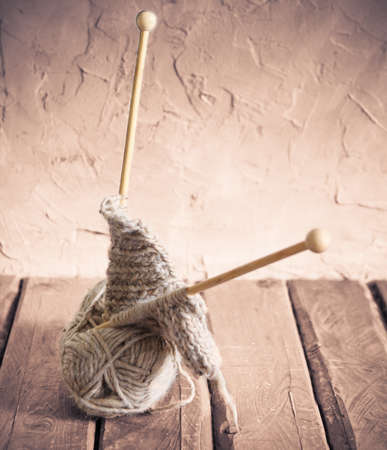Balls of yarn and knitting on a wooden table. Retro style