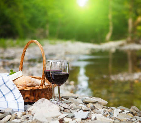 Red wine, cheese and bread served at a picnic. の写真素材