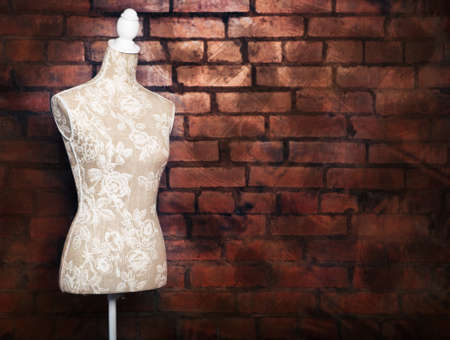 Antique Dress Form With Vintage Look Against Brick Lizenzfreie Antique Dress Form With Vintage Look