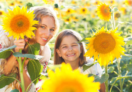 Happy mother and her little daughter in the sunflower field. Summer funの写真素材