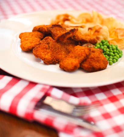 Close up of fish and chips with peas and a slice of lemonの写真素材