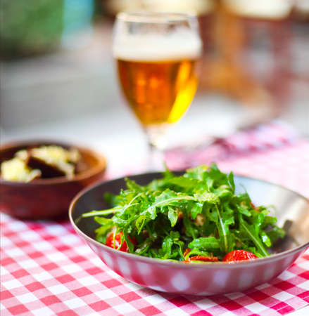 One glass of light beer with salad in the pubの写真素材