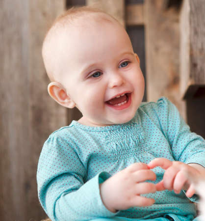 Cute smiling ten month old baby on the wooden background