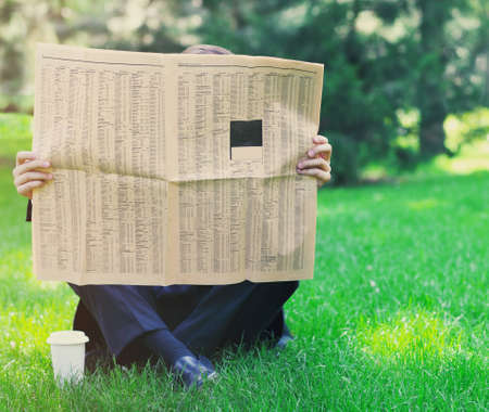 Close up of the hands of the businessman with a newspaper. Outdoorsの写真素材