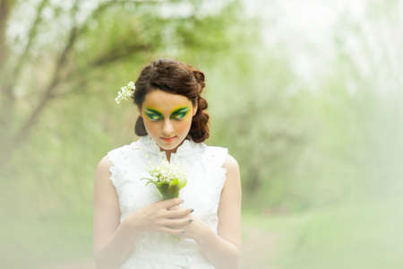 Portrait of a young girl with lily of the valley in her hairの写真素材