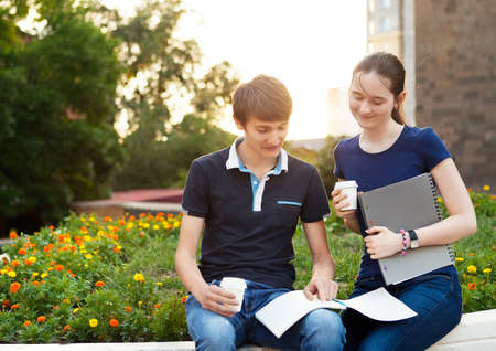 Couple of college students during a brake between classes - chatting, comparing notes, having funの写真素材