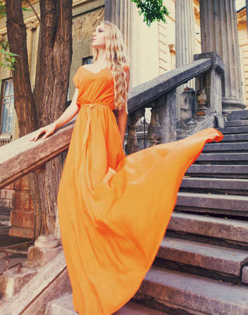 Portrait of a beautiful blond woman in long dress outdoorsの写真素材