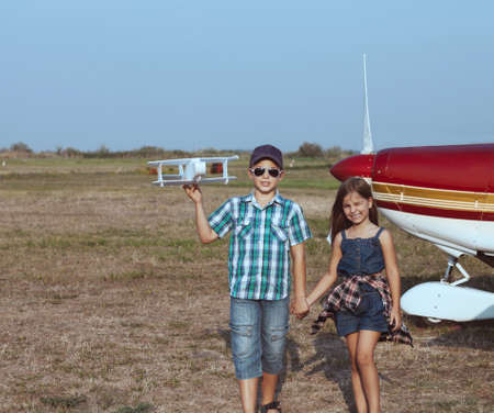 Little boy and little girl pilot with handmade plane at the airport の写真素材