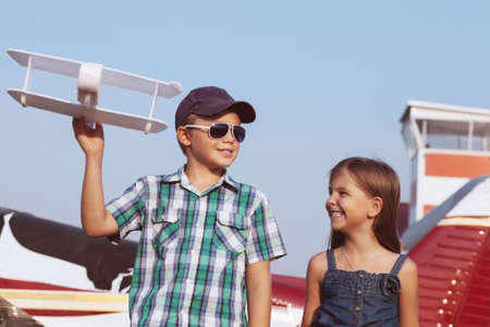 Little boy and little girl pilot with handmade plane at the airport の写真素材