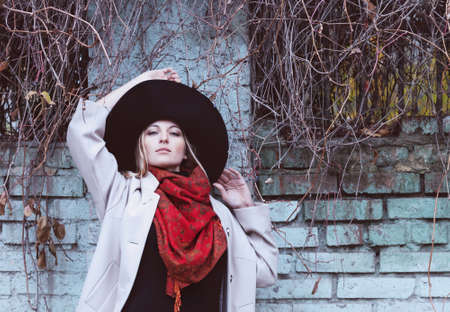 Portrait of the beautiful woman wearing black hat enjoying the sunny autumn dayの写真素材