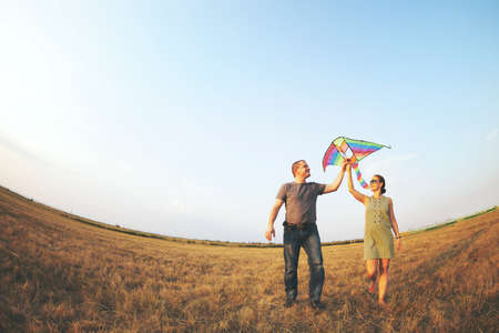 Happy young couple in love with flying a kite の写真素材
