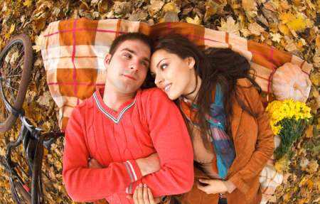 Happy young couple with bicycle in autumn parkの写真素材