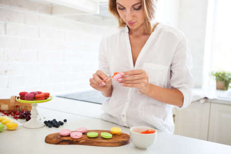 Woman cooking homemade macarons at the kitchenの写真素材