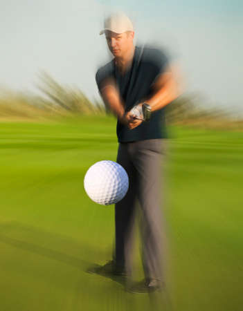 Golf ball just coming off the tee from a golfer in swingの写真素材