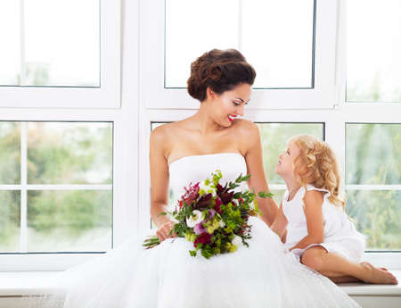 Smiling happy bride and a flower indoors. Horizontal shotの写真素材