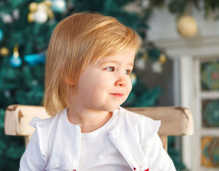 Cute little Christmas baby by the Christmas treeの写真素材