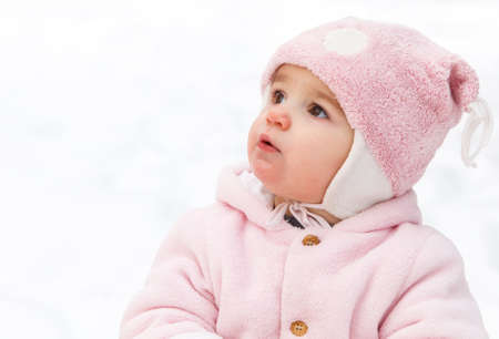 Happy funny baby in winter park. Snow is background