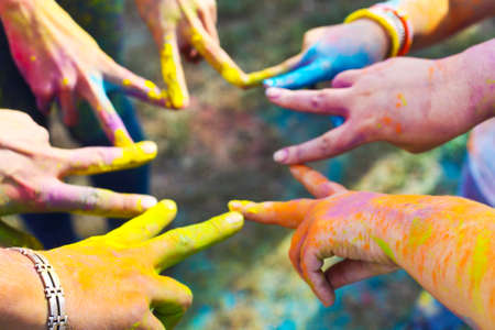 Friends putting their hands together in a sign of unity and teamwork. Holi colors festival. Friendship conceptの写真素材