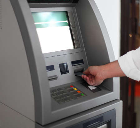 Close up of hand of a man using banking machineの写真素材
