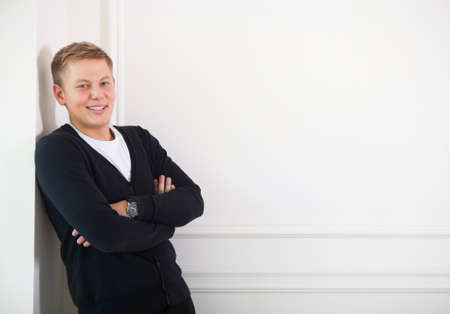 Close up portrait of young smiling cute teenager near the white wallの写真素材