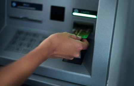 Close up of hand of a woman using banking machineの写真素材