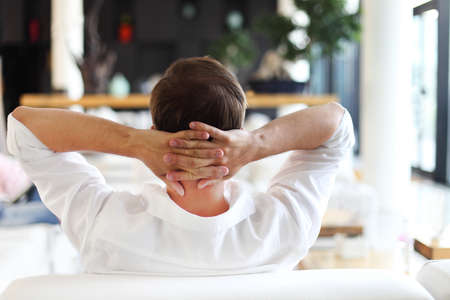 Young relaxing man lying on sofa and having restの写真素材